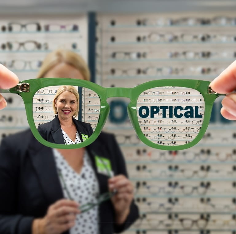 Optical - Hero image showing pair of glasses with clear view of an optician, whilst outside the glasses is blurred